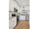 Modern kitchen with stainless steel appliances, white cabinetry, and hardwood floors at 42490 W Vincent Dr, Maricopa, AZ 85138