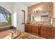 Spa-like bathroom with a large soaking tub, custom cabinets, dual sinks and scenic view at 42613 N 111Th Pl, Scottsdale, AZ 85262