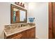 Bathroom with a marble countertop, decorative mirror, and wooden cabinets for a luxurious feel at 42613 N 111Th Pl, Scottsdale, AZ 85262