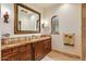 Bathroom with a large mirror, custom wood cabinets, marble counters, and stylish fixtures at 42613 N 111Th Pl, Scottsdale, AZ 85262