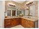 Elegant bathroom with dual vanities, warm lighting, granite counters and decorative mirrors at 42613 N 111Th Pl, Scottsdale, AZ 85262