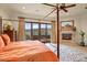 Comfortable bedroom with a four-poster bed, fireplace, and large windows offering views of the Arizona landscape at 42613 N 111Th Pl, Scottsdale, AZ 85262