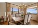 Bright dining room boasts large windows with mountain views and a stylish chandelier above at 42613 N 111Th Pl, Scottsdale, AZ 85262