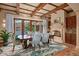 Inviting dining area showcases a stone fireplace, rustic beams, and access to outdoor space at 42613 N 111Th Pl, Scottsdale, AZ 85262