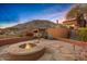 A stone fire pit with seating area and desert landscaping enhance the outdoor space of this hillside property at 42613 N 111Th Pl, Scottsdale, AZ 85262