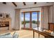 Inviting living room with fireplace, exposed beam ceiling, and doors to the outdoor terrace with views at 42613 N 111Th Pl, Scottsdale, AZ 85262