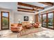 Living room featuring beamed ceilings, tiled floors, and french doors leading to an outdoor patio at 42613 N 111Th Pl, Scottsdale, AZ 85262