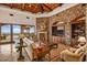 Cozy living room featuring a stone accent wall, fireplace, wood-beamed ceiling, and seamless indoor-outdoor living at 42613 N 111Th Pl, Scottsdale, AZ 85262