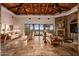 Inviting living room with beamed ceilings, stone fireplace, travertine floors, and expansive windows showcasing mountain views at 42613 N 111Th Pl, Scottsdale, AZ 85262