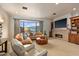 Inviting living room boasts a stone fireplace, neutral carpet, large window and comfortable seating at 42613 N 111Th Pl, Scottsdale, AZ 85262