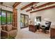 Comfortable home office featuring wood beam ceiling, neutral walls, and a large window with views to the garden at 42613 N 111Th Pl, Scottsdale, AZ 85262