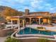 Backyard pool featuring a spa and covered gazebo, with a stone patio perfect for outdoor entertaining at 42613 N 111Th Pl, Scottsdale, AZ 85262