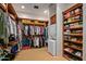 Spacious walk-in closet with custom wood built-ins and storage solutions, including laundry unit at 42613 N 111Th Pl, Scottsdale, AZ 85262