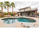 Backyard oasis with a sparkling pool, covered patio, and lush palm trees at 4365 E Anderson Dr, Phoenix, AZ 85032