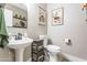 Charming bathroom with a stylish pedestal sink, unique wall art, and modern fixtures at 4365 E Anderson Dr, Phoenix, AZ 85032