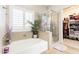 Bright bathroom features a soaking tub, a glass shower, and a walk-in closet at 4365 E Anderson Dr, Phoenix, AZ 85032