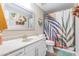 Stylish bathroom features a white vanity, large mirror, and a colorful, tropical-themed shower curtain at 4365 E Anderson Dr, Phoenix, AZ 85032