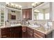 Corner view of bathroom with granite counters, dual sinks, and dark wood cabinets at 4503 E Elmwood St, Mesa, AZ 85205