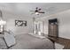 View of main bedroom with wood floors, ceiling fan, dresser, and access to the backyard at 4503 E Elmwood St, Mesa, AZ 85205