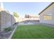 Fully fenced backyard featuring artificial grass, gravel, and a desert landscaped fire pit at 4514 W Ellis St, Laveen, AZ 85339