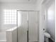 Bright bathroom featuring soaking tub, sleek fixtures, glass block window, and a glass-enclosed shower at 4514 W Ellis St, Laveen, AZ 85339