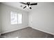 Bedroom features neutral walls, plush carpeting, window, and a modern ceiling fan at 4514 W Ellis St, Laveen, AZ 85339