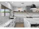 Bright kitchen with white cabinetry, marble countertops, stainless steel appliances, floating shelves, and a view from the window at 4602 E Oberlin Way, Cave Creek, AZ 85331