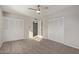 A carpeted bedroom featuring a ceiling fan and double door closets at 4703 N 26Th Ln, Phoenix, AZ 85017