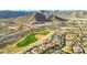 Aerial view of golf course community featuring mountain views, lush green fairways, and luxury homes at 4820 N 210Th Ave, Buckeye, AZ 85396