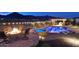 Beautifully lit resort-style backyard with a pool, hot tub, fire pit, and an outdoor kitchen at 4820 N 210Th Ave, Buckeye, AZ 85396