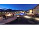 Beautifully lit resort-style backyard with a pool, hot tub, fire pit, and an outdoor kitchen at 4820 N 210Th Ave, Buckeye, AZ 85396