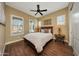 Bedroom with wood floors, a ceiling fan, and bright natural light from two windows at 4820 N 210Th Ave, Buckeye, AZ 85396