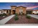 Beautiful stone-faced home featuring a well-manicured front yard and a spacious three-car garage at 4820 N 210Th Ave, Buckeye, AZ 85396