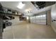 Organized three-car garage featuring coated floors, tool racks, and overhead storage at 4820 N 210Th Ave, Buckeye, AZ 85396