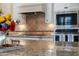 A well-appointed kitchen features stainless steel appliances and custom tile backsplash at 4820 N 210Th Ave, Buckeye, AZ 85396