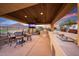 Covered outdoor kitchen with a built-in grill, bar seating, ceiling fan and views of the golf course at 4820 N 210Th Ave, Buckeye, AZ 85396