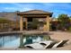 Covered outdoor kitchen with a built-in grill, bar seating and views of the pool at 4820 N 210Th Ave, Buckeye, AZ 85396