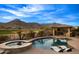 Resort-style pool and hot tub featuring built-in lounge chairs and an outdoor kitchen with bar seating at 4820 N 210Th Ave, Buckeye, AZ 85396