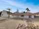 Backyard of the home featuring desert landscaping, solar panels on the roof, and palm tree accents at 5432 E Juniper Ave, Scottsdale, AZ 85254