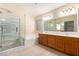 Bathroom featuring a walk-in shower, soaking tub, and dual vanity for added convenience at 6060 W Charter Oak Rd, Glendale, AZ 85304