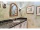 Charming powder room with decorative mirror, granite countertop, and stylish fixtures at 6801 N 1St Pl, Phoenix, AZ 85012