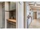 A view of the kitchen through the hallway, featuring white cabinets, granite counters, and stainless steel appliances at 6801 N 1St Pl, Phoenix, AZ 85012