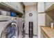 Convenient laundry room featuring modern washer and dryer, neutral wall paper, and overhead storage at 6801 N 1St Pl, Phoenix, AZ 85012