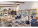 Bright living room boasts a ceiling fan, wood beams, built-in shelving, and opens up to another room through glass doors at 6801 N 1St Pl, Phoenix, AZ 85012