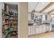 Open walk-in pantry next to a kitchen featuring stone counters, stainless steel appliances, and white cabinets at 6801 N 1St Pl, Phoenix, AZ 85012