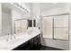 Bathroom with a double sink vanity and glass-enclosed shower and bath at 7601 E Roosevelt St # 1007, Scottsdale, AZ 85257