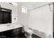 Bathroom features dark wood cabinets, black tile floors, and a shower with white curtain at 7601 E Roosevelt St # 1007, Scottsdale, AZ 85257