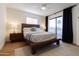 Inviting bedroom featuring a wooden platform bed, natural light, and dark accent curtains at 7755 E Thomas Rd # 8, Scottsdale, AZ 85251