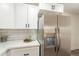 Kitchen featuring white cabinets, stainless refrigerator and modern quartz countertop at 7801 N 44Th Dr # 1059, Glendale, AZ 85301