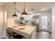 Kitchen island with quartz countertop and stainless steel appliances gleams beneath pendant lighting at 7801 N 44Th Dr # 1059, Glendale, AZ 85301